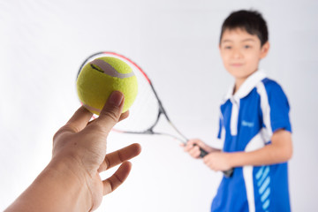 Little boy playing tennis racket and tennis ball in hand