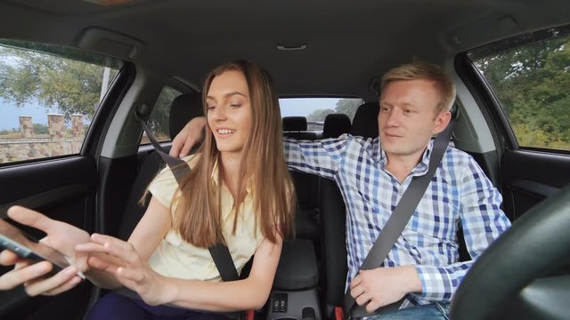 Young adult couple making selfie in a car. 4K