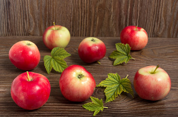 Яблоки,урожай лета.\Яблоки,листья на фоне деревянного стола.