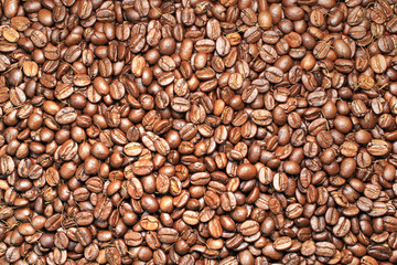 Coffee beans on brown background.