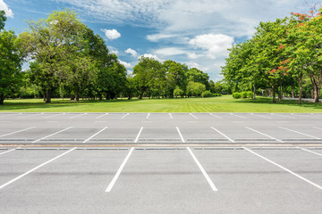Empty parking lot against green lawn in city park - Powered by Adobe