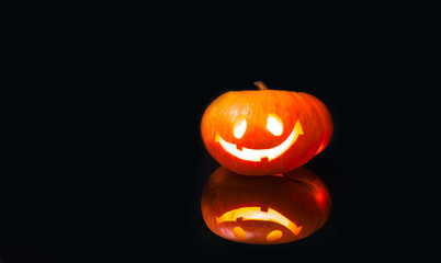 Jack-o'-lantern on black background with reflection