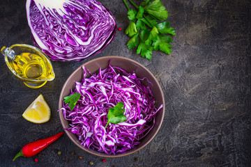 Purple cabbage salad and ingredients on a dark background.