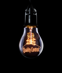 Hanging lightbulb with glowing Quality Control concept.