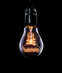 Hanging lightbulb with glowing Troubleshooting concept.