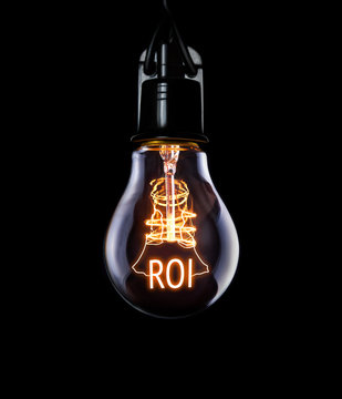 Hanging lightbulb with glowing Return on Investment concept.