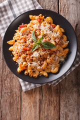gomiti pasta with white beans and cheese on a plate close-up. Vertical top view

