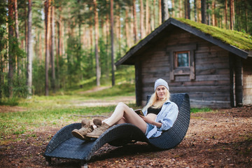 Obraz premium Girl with a book resting on a lounger in a forest glade