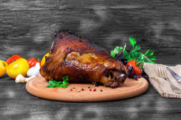 shin, knee wild boar - roast pork leg with vegetables on black background