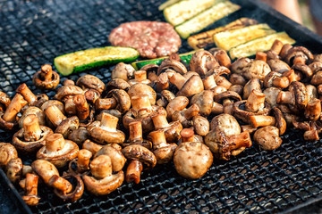 Champignon white mushrooms grilled on grill or BBQ steam and small drops of water. Cooking mushrooms on the grill. Portobello mushrooms marinated and grilling. Grilled vegetables on a grill close up.