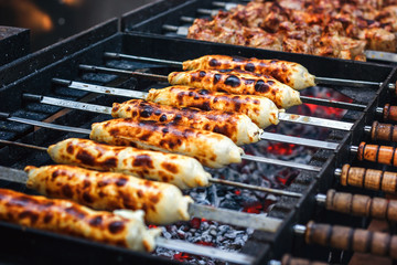 Georgian traditional dish - khachapuri, pastry with cheese and tomatoes on skewer fried on the grill. Fresh hot tasty street food. Cooking food. Preparation dish of Middle Eastern cuisine.
