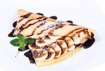 Pancakes stuffed bananas and chocolate on a plate