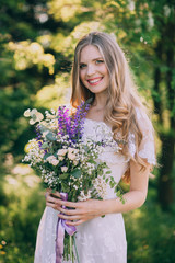 stylish boho bride holding rustic bouquet of amazing flowers