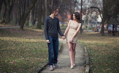Obraz premium Young, happy and attractive couple enjoying together in walk through the city park. Urban outdoors.