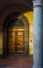 Antique wooden door in a Pisa street. Tuscany, Italy.