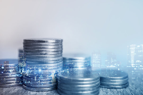 Double exposure of city and rows of coins for finance and banking concept

