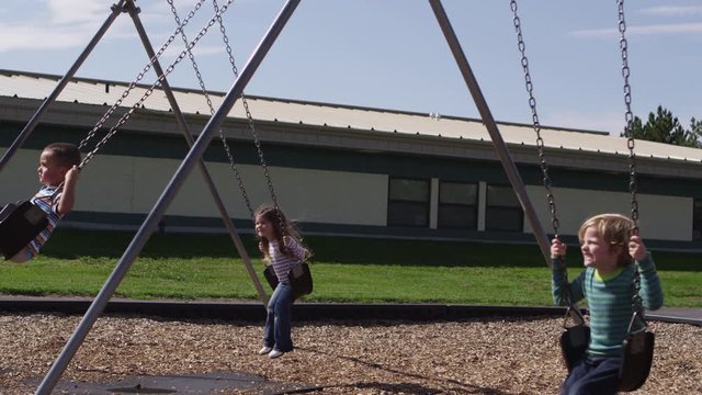 Little children playing on swings - 4K