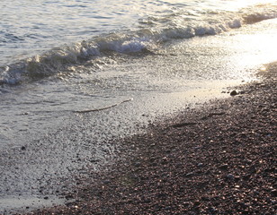 Fototapeta na wymiar Evening sea beach with shingle in summer at sunset
