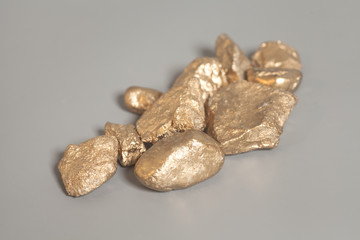 Golden nuggets on gray background