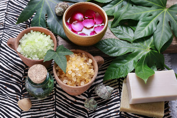 Bowls of green sea salt, bottle of essential oil and bars of soa