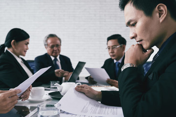 Concentrated young lawyer examining document before trial