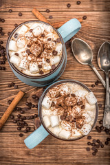 Obraz na płótnie Canvas Cocoa with marshmallows and chocolate on a wooden table.