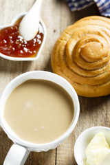 Breakfast table, served with coffee, jam and fresh bun
