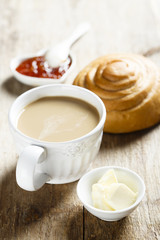 Breakfast table, served with coffee, jam and fresh bun