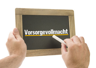 Hand schreibt Vorsorgevollmacht auf Kreidetafel