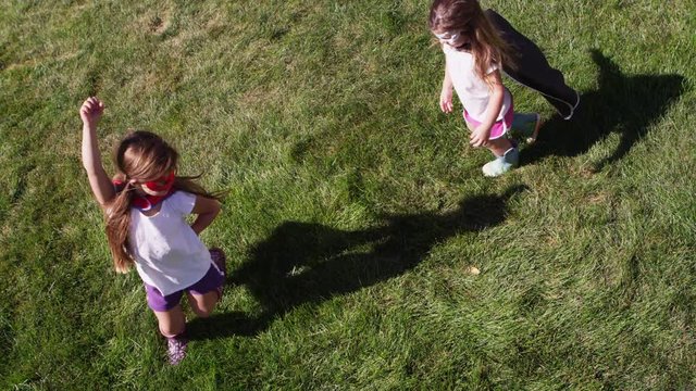 Young girls dressed as superheroes playing outside - 4K