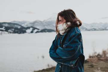 Young brunette woman cold at winter riverside