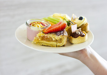 Dessert on a plate. Delicious sweet dessert. Refreshments. Souffle and cakes on a white plate
