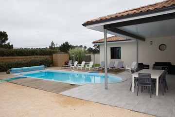Rear garden of a contemporary home with tiled swimming pool