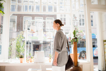 Woman standing inside shop at storefront