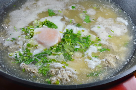 egg on hot boiled rice with minced pork dressing parsley in pot