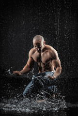  athletic man striking with a hand on water