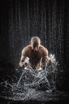  athletic man striking with a hand on water