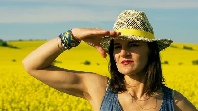 Woman looking in the distance on the field, steadycam shot, slow motion shot at 240fps
