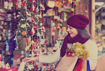 Happy young woman choosing Christmas decoration