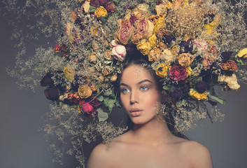 Beauty fashion female portrait with large garland dried flowers.