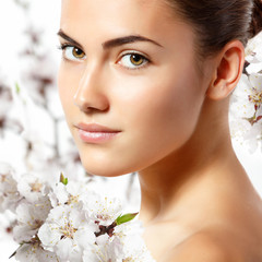 teen girl beauty portrait looking at camera over blooming tree w