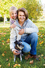 Naklejka na ściany i meble Portrait of smiling woman with cute little girl in autumn park