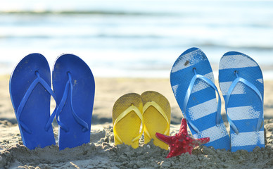 Color Flip flops on the sandy beach next to sea