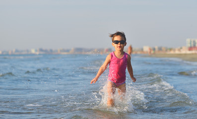Cute child running in the waves