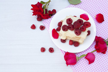 a piece of cake with raspberries and roses