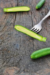 Zucchini auf Holz mit Gabel (Cucurbita)