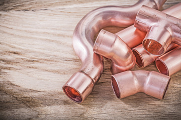 Copper water pipe connectors on wooden board plumbing brassware 