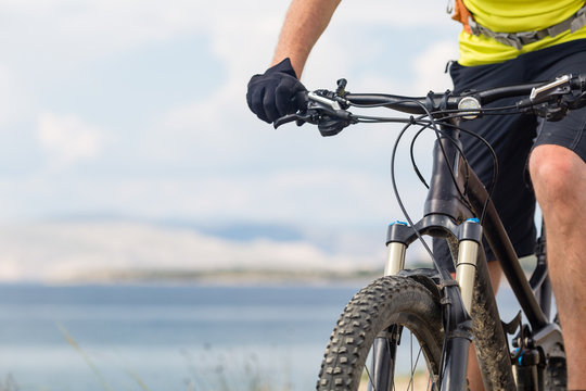 Mountain biker riding on bike at the sea and summer mountains. Sport and training outdoors.