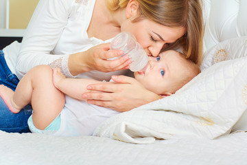The concept of caring for the baby. Mother feeding baby with mil