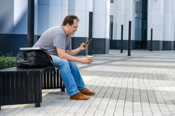 Middle age man reading tablet sitting outdoors